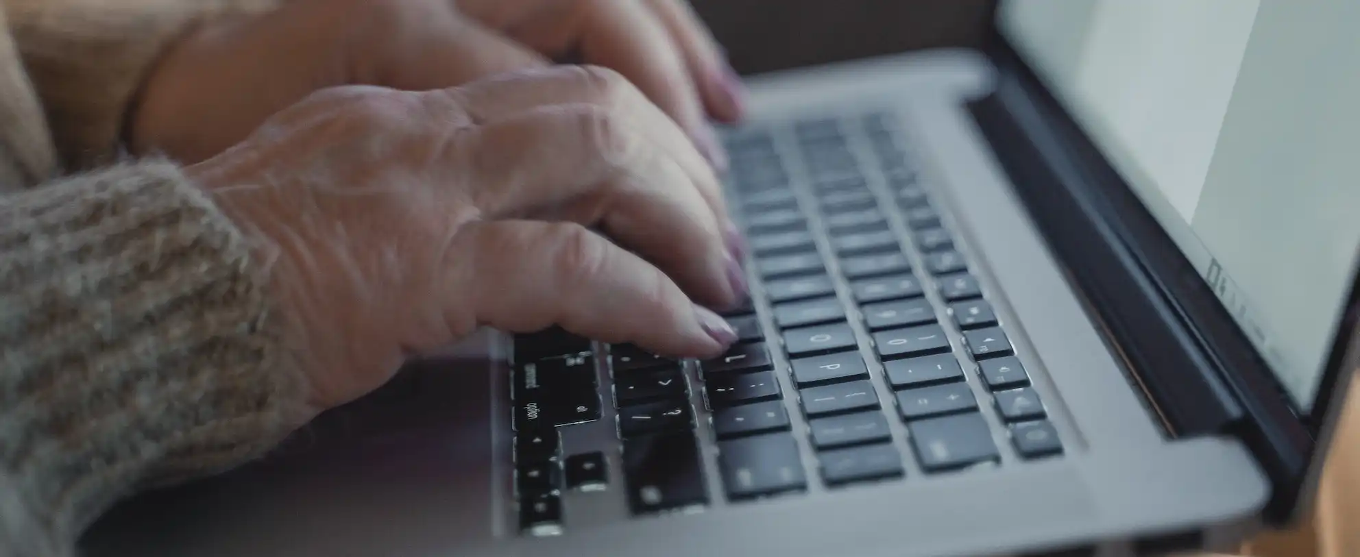 Photograph of Old People Hand Typing on Macbook